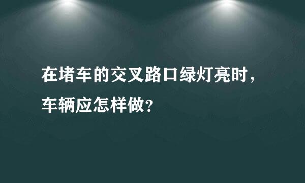 在堵车的交叉路口绿灯亮时，车辆应怎样做？